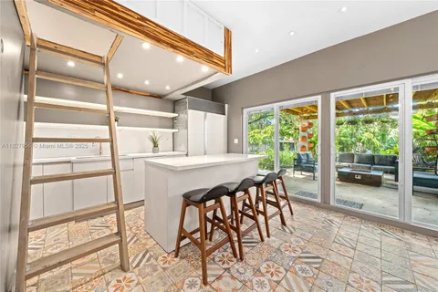 a dining room with furniture and large windows