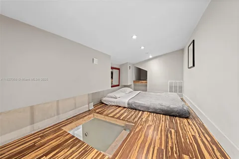 a spacious bedroom with a bed and a rug