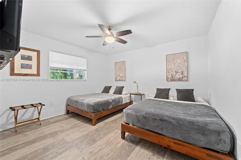 a bedroom with two beds and painting on the wall