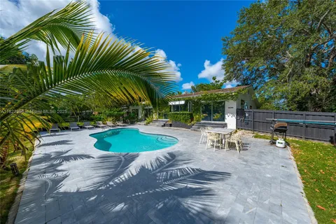a view of a swimming pool with chairs in patio