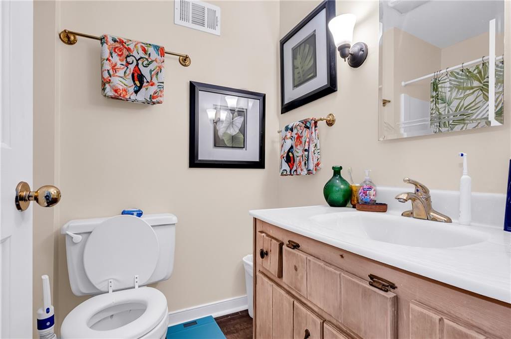 2894 McPherson Road Northeast Roswell, GA 30075 - Photo 14 of 24 a bathroom with a toilet a sink and mirror