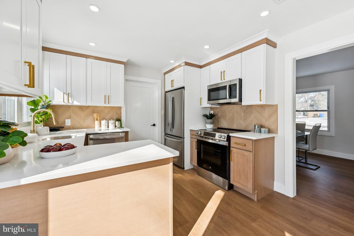 2 Sylvan Lane Willingboro, NJ 08046 - Photo 10 of 26 a kitchen with stainless steel appliances a stove a sink a refrigerator white cabinets and wooden floor