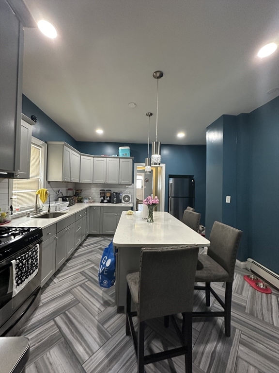 115 Addison Street Chelsea, MA 02150 - Photo 3 of 16 a large kitchen with a table and chairs