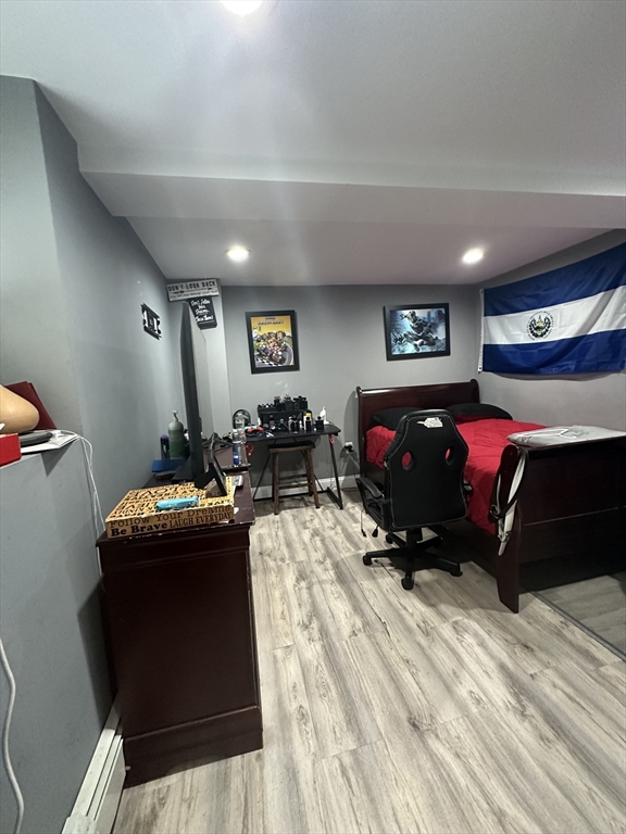 115 Addison Street Chelsea, MA 02150 - Photo 6 of 16 a bedroom with furniture and a gym equipment