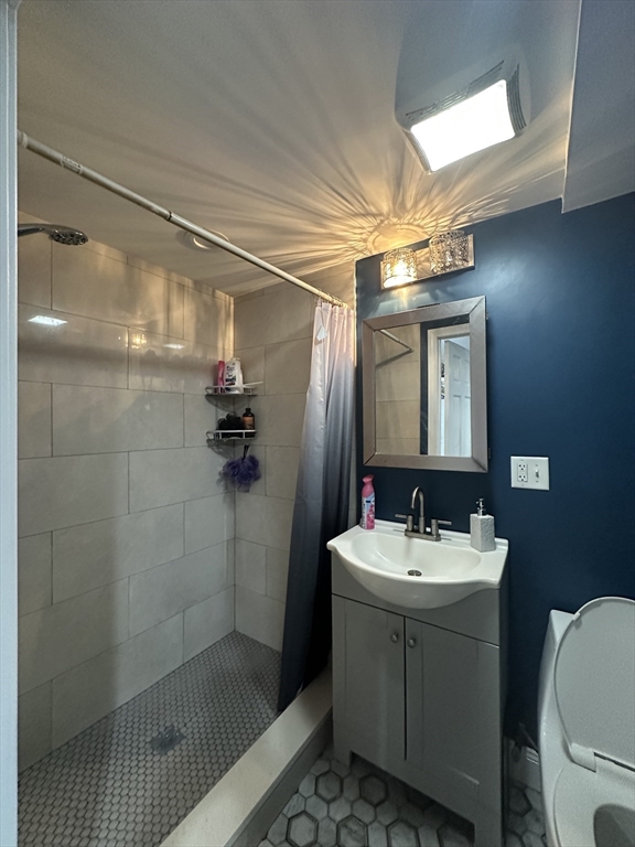 115 Addison Street Chelsea, MA 02150 - Photo 9 of 16 a bathroom with a sink mirror toilet and shower