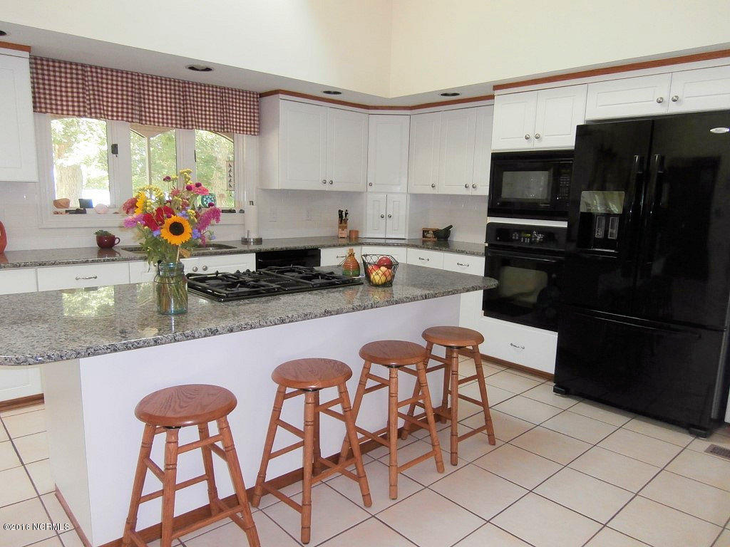 6907 Riverpoint Road Elm City, NC 27822 - Photo 8 of 44 Built in Microwave, Wall Oven & Gas Jenn Air Cook Top with down draft on the Granite Work Island, which adds additional Food Prep Area & Eating at the Bar options.