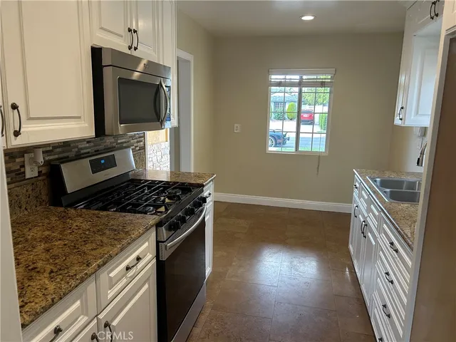 a kitchen with wooden floor and a stove top oven