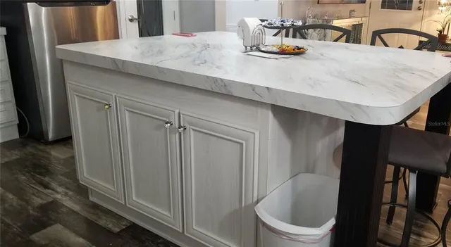 a bathroom with a granite countertop sink a toilet and with mirror