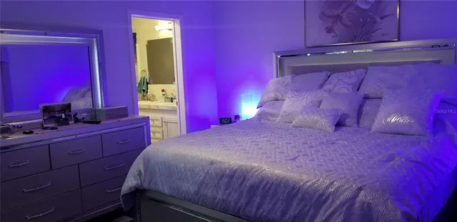 a bedroom with a bed and a mirror on dresser