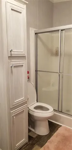a white toilet sitting next to a shower
