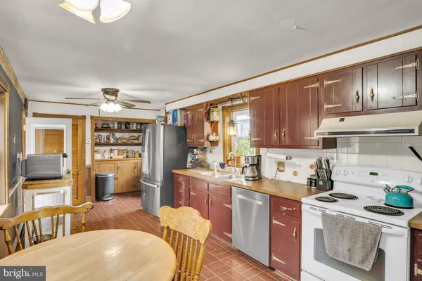a kitchen with a stove a refrigerator and wooden cabinets