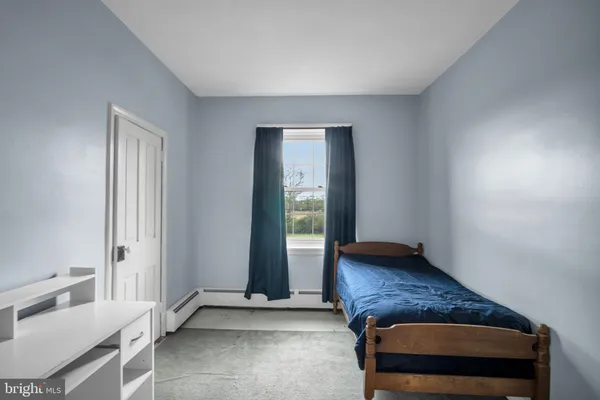 a living room with a dresser and a window