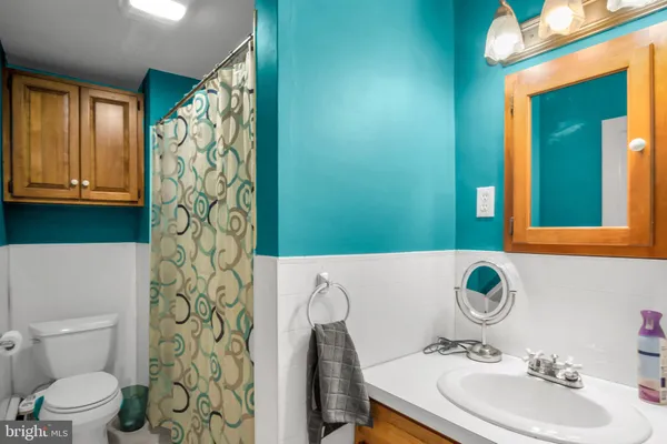 a bathroom with a sink toilet and mirror