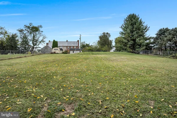 a view of a field with an trees in the background