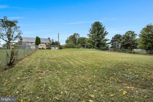 a view of a field with trees in the background