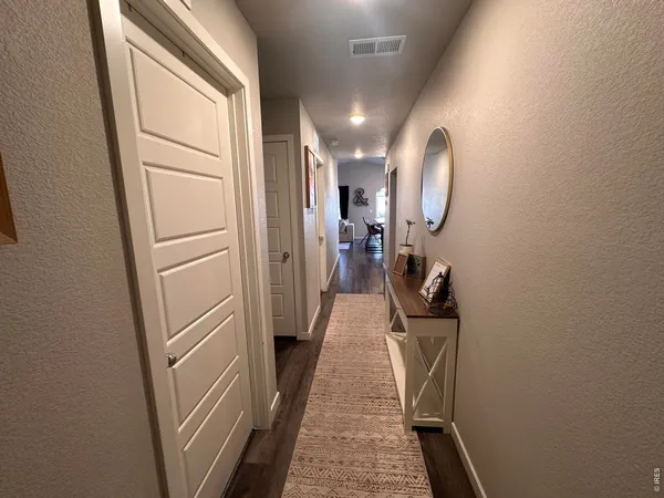 a view of a hallway with wooden floor and entryway