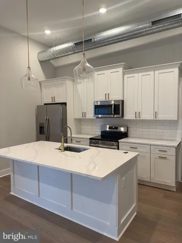a kitchen with a refrigerator a sink and cabinets