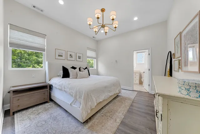 a bedroom with a large bed and a chandelier