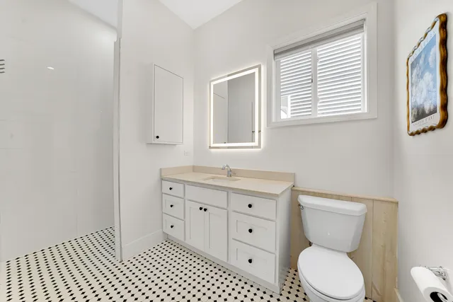 a bathroom with a toilet a sink and mirror