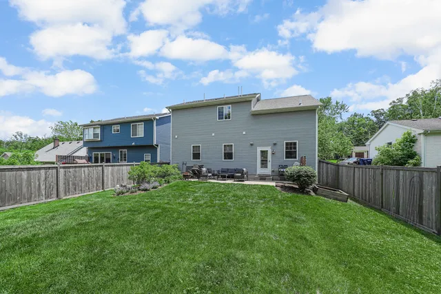 a view of a house with backyard and sitting area