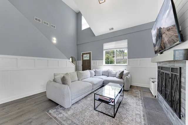 a living room with furniture a fireplace and a large window