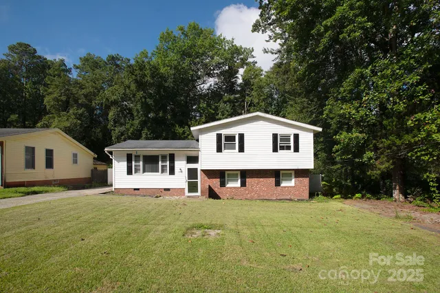 a front view of a house with a yard and trees