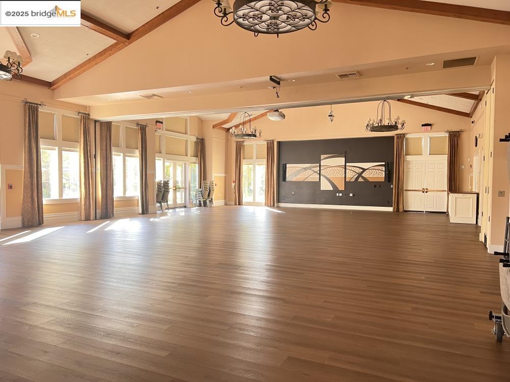 599 Pomona Drive Brentwood, CA 94513 - Photo 29 of 35 Miscellaneous room featuring wood finished floors, beam ceiling, high vaulted ceiling, a chandelier, and plenty of natural light