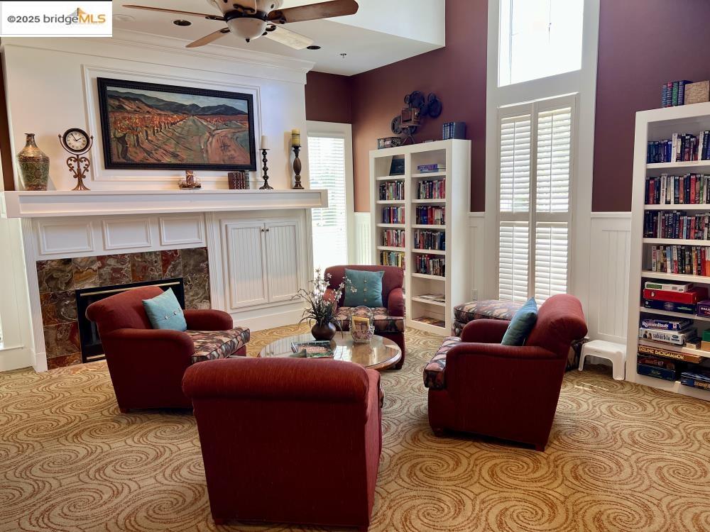599 Pomona Drive Brentwood, CA 94513 - Photo 34 of 35 Living area with a high end fireplace, light carpet, ceiling fan, and wainscoting