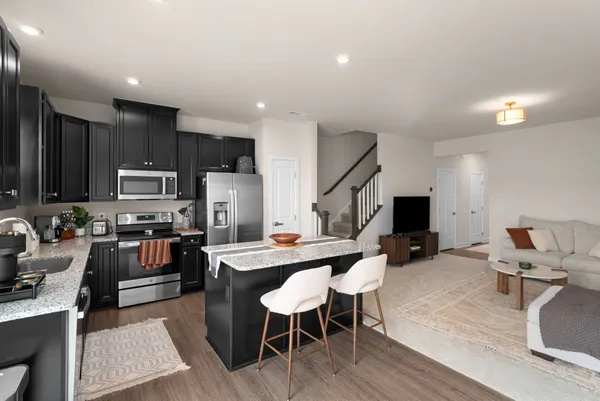 a kitchen with granite countertop wooden cabinets a refrigerator and a sink