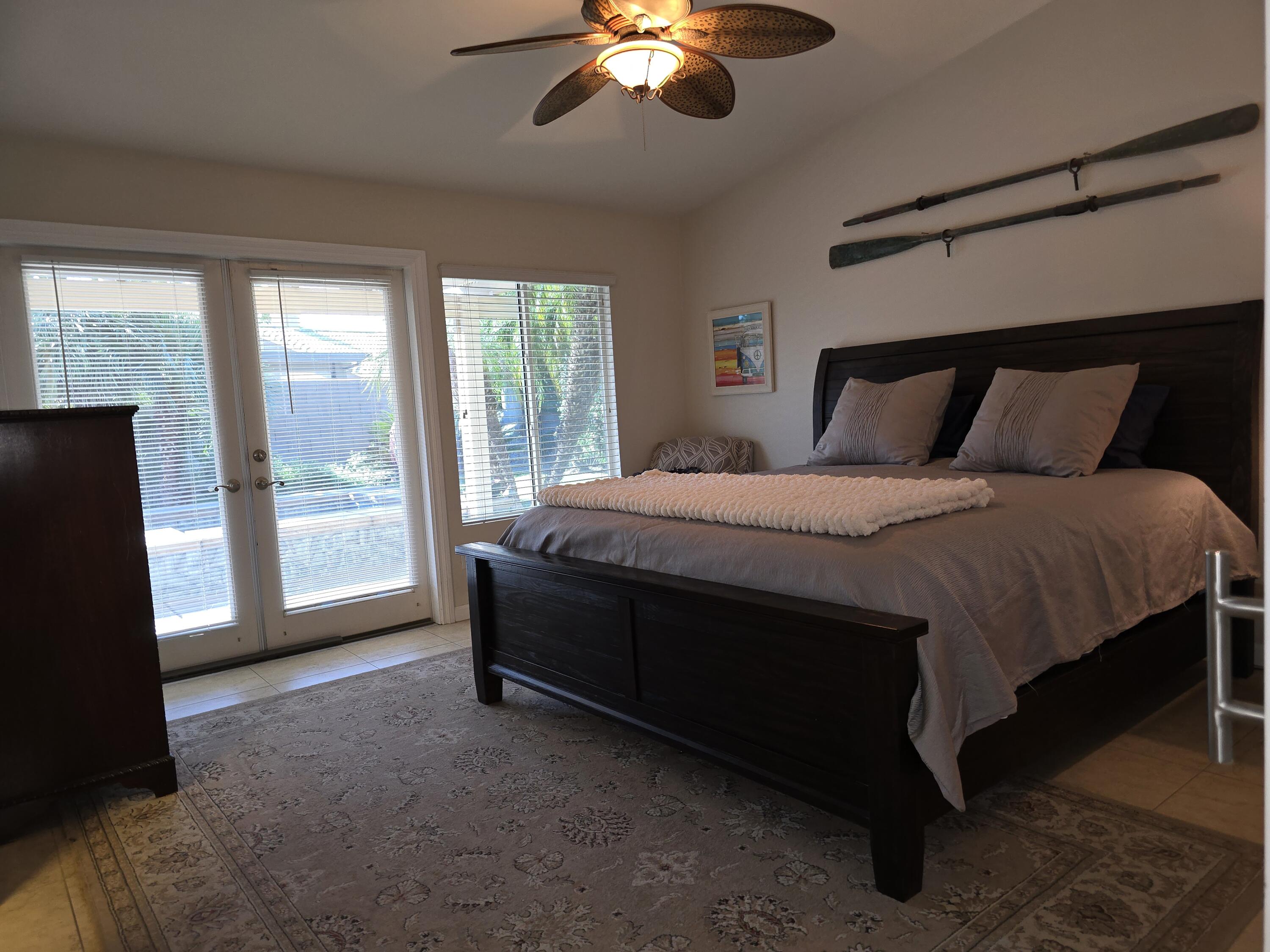 47719 Avocado Court Indio, CA 92201 - Photo 11 of 22 a spacious bedroom with a bed and a chandelier