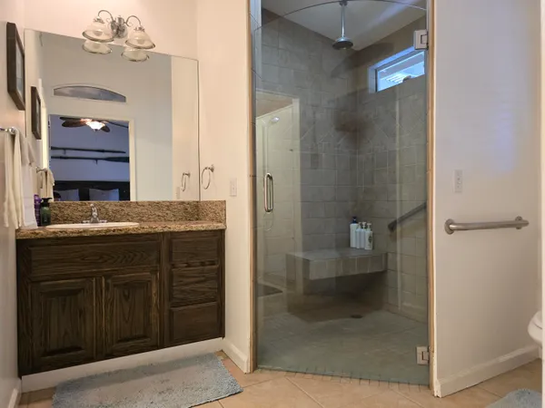a bathroom with a granite countertop sink a toilet and shower