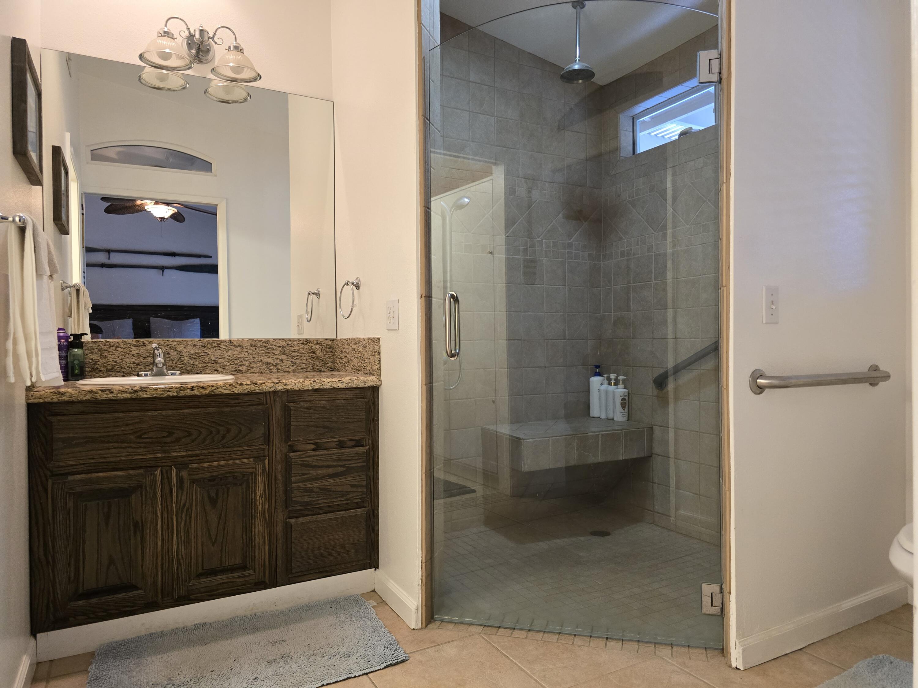 47719 Avocado Court Indio, CA 92201 - Photo 12 of 22 a bathroom with a granite countertop sink a toilet and shower