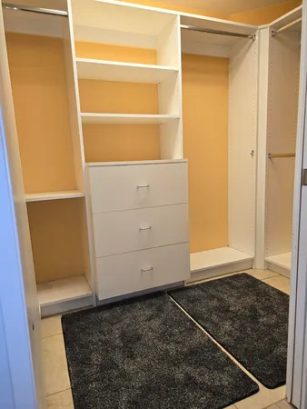 a view of walk in closet with empty racks