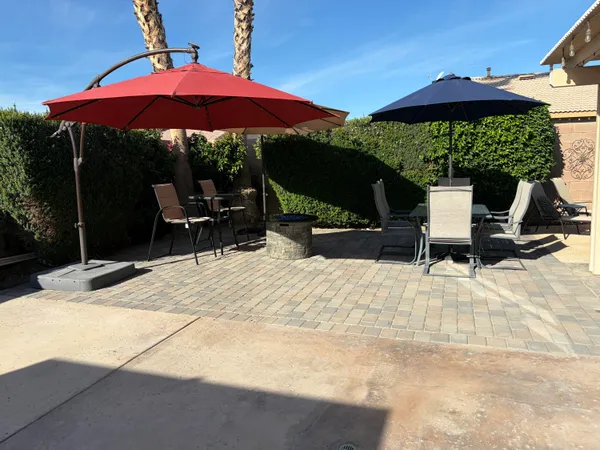 a view of a patio with a table and chairs under an umbrella