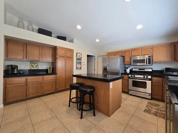 a kitchen with stainless steel appliances granite countertop a stove top oven a sink a counter top space and cabinets