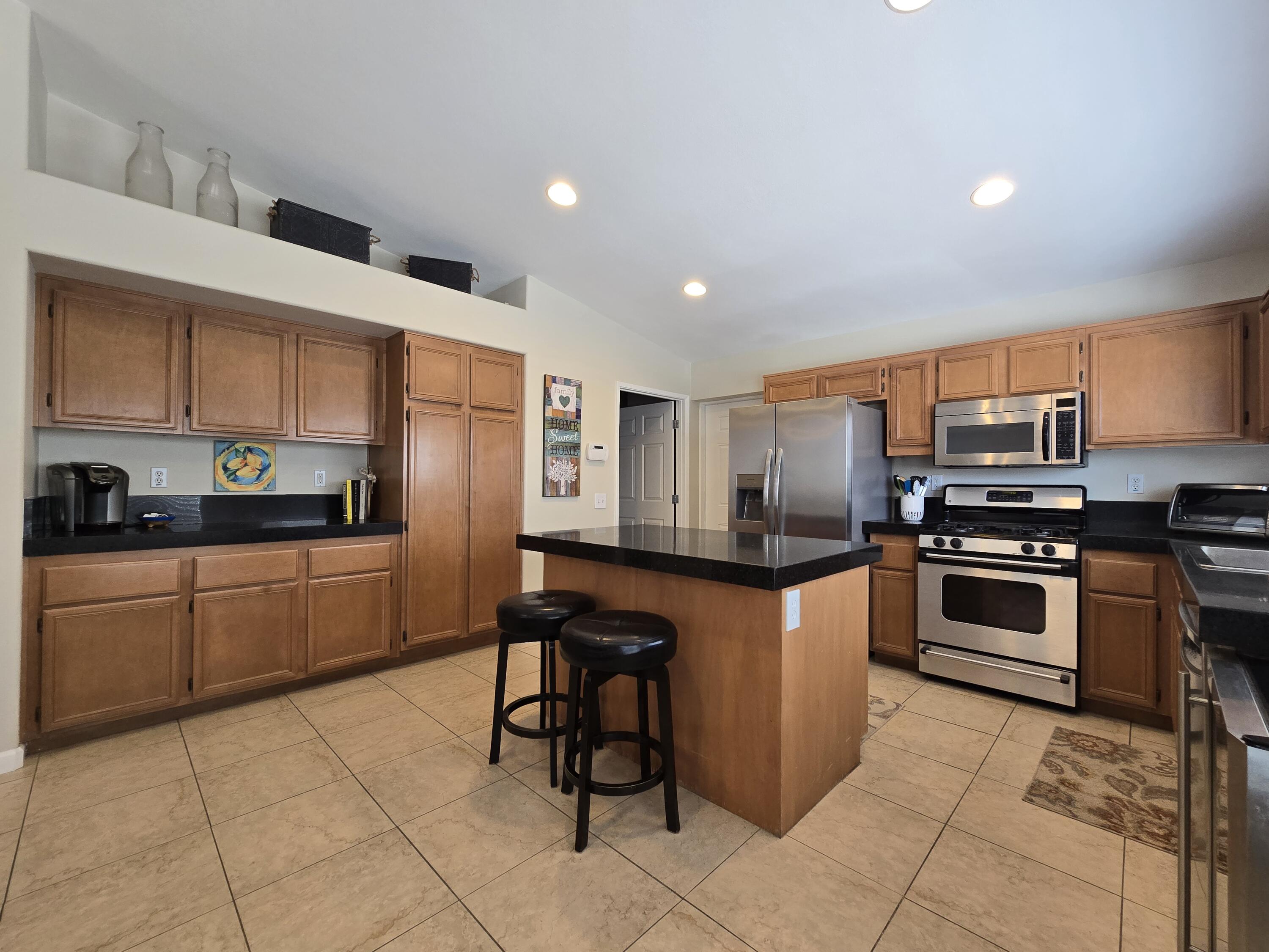47719 Avocado Court Indio, CA 92201 - Photo 5 of 22 a kitchen with stainless steel appliances granite countertop a stove top oven a sink a counter top space and cabinets