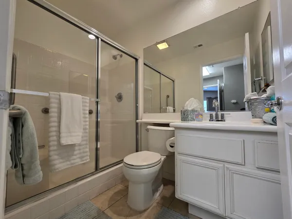 a bathroom with a shower a sink a toilet and a mirror