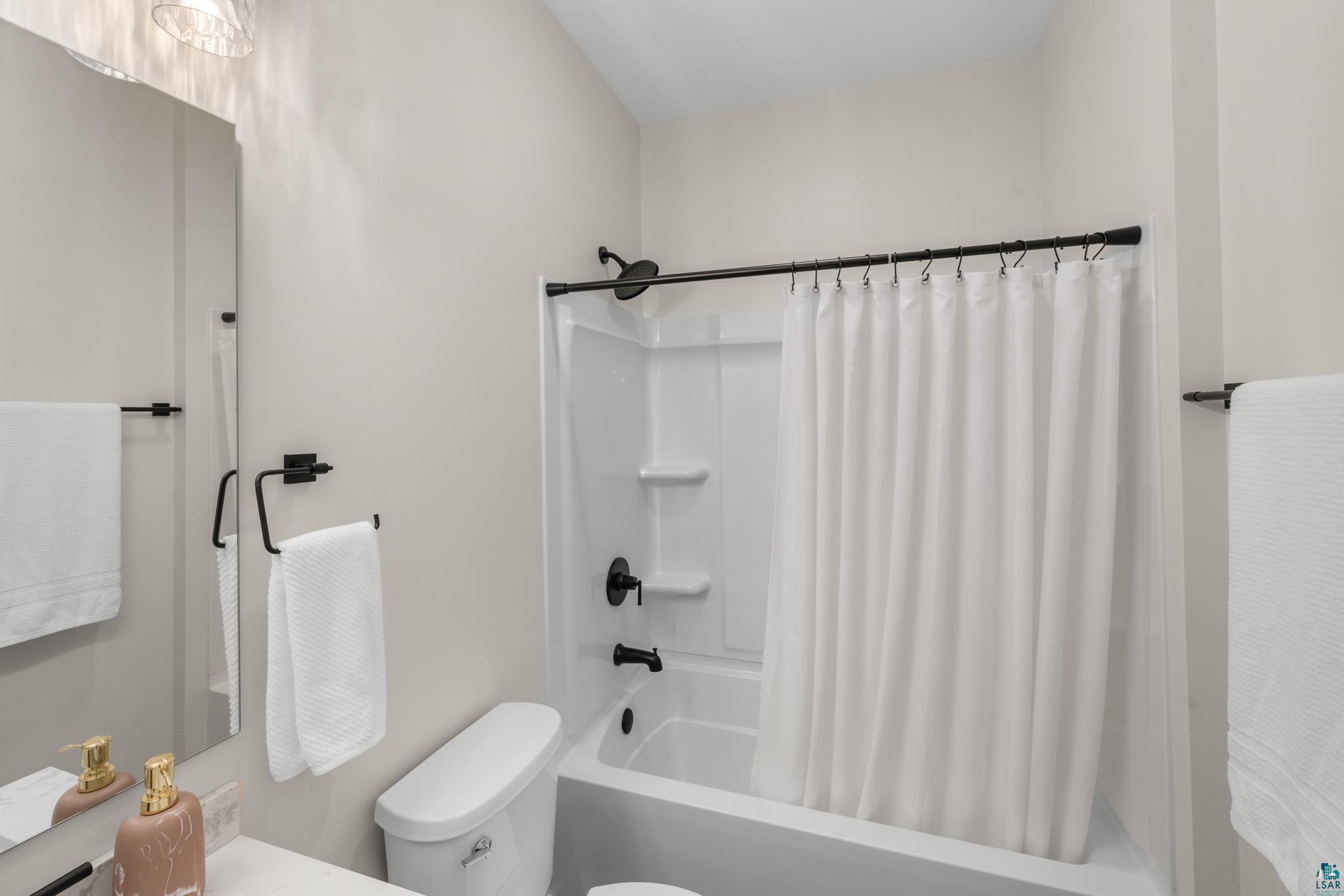 1241 Airport Road Two Harbors, MN 55616 - Photo 40 of 54 Tub/shower combination with matte black fixtures, white shower curtain, and a white toilet