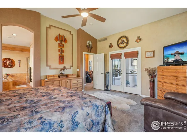 a spacious bedroom with a bed and a dresser