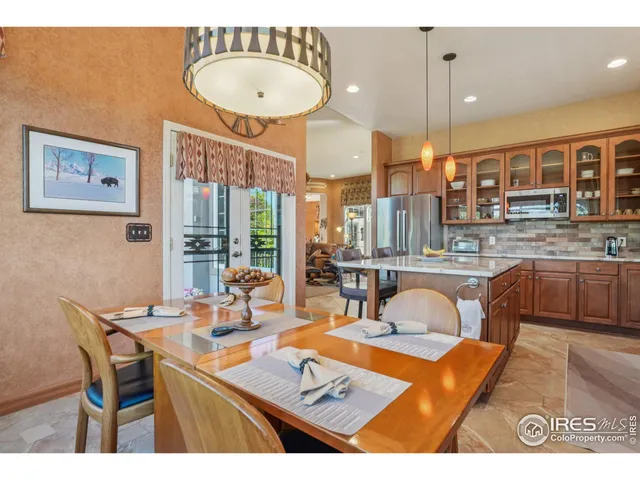 a view of a dining room and hall with a table and chairs