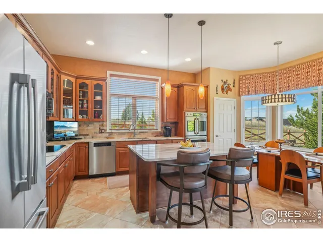 a dining hall with stainless steel appliances kitchen island granite countertop a stove and large window