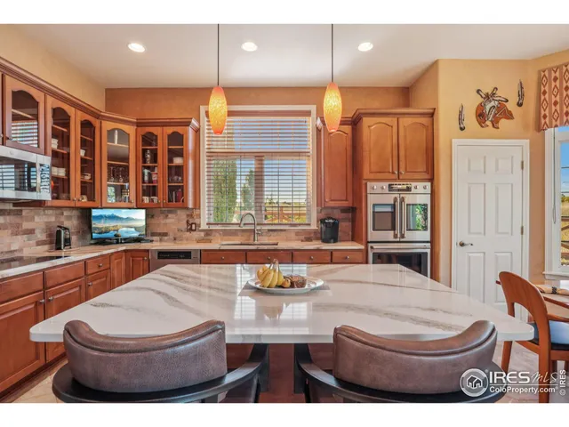 a living room with furniture a large window and kitchen view