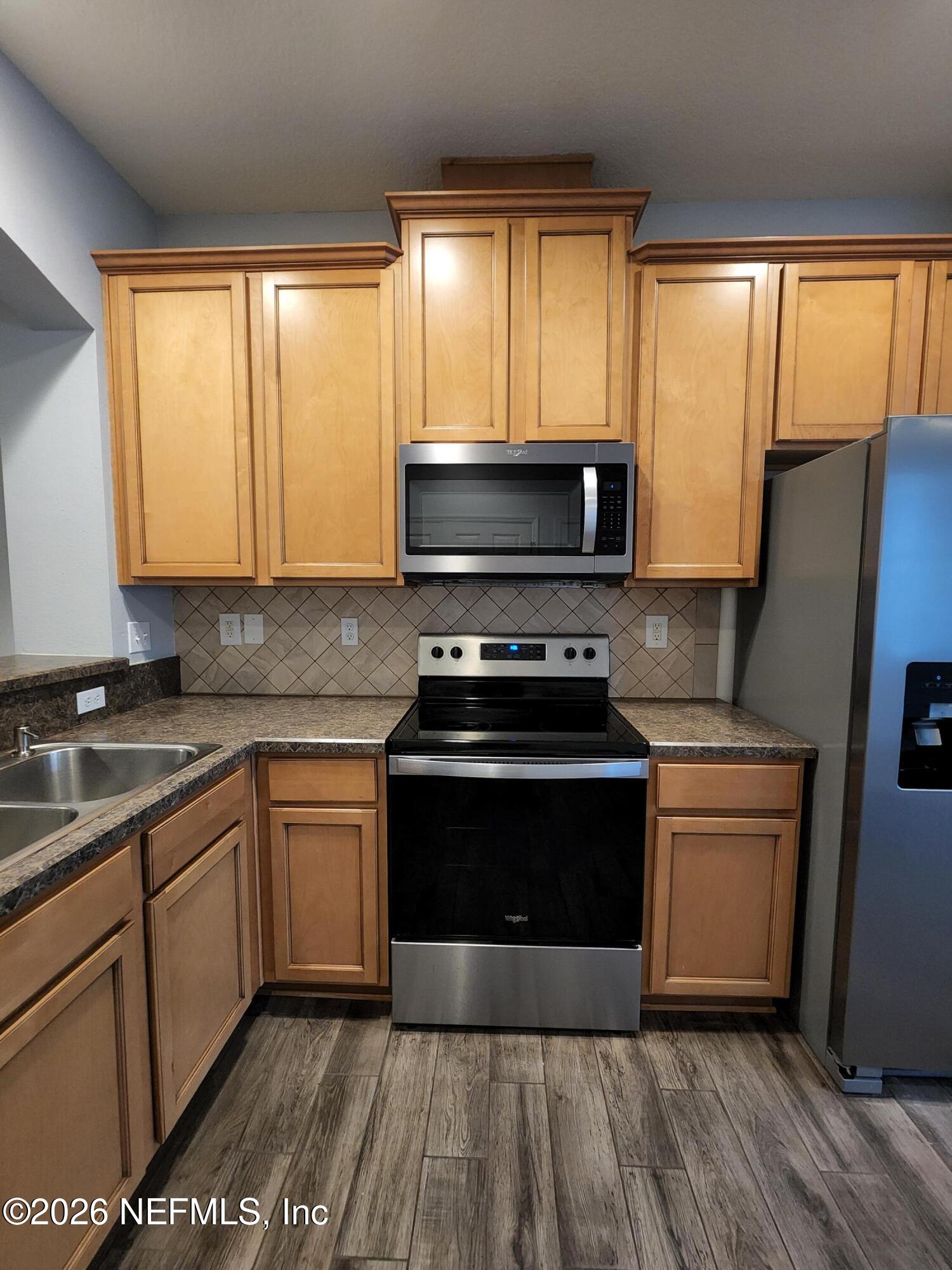 13030 Shallowater Road Jacksonville, FL 32258 - Photo 11 of 27 a kitchen with granite countertop a stove a sink and a microwave