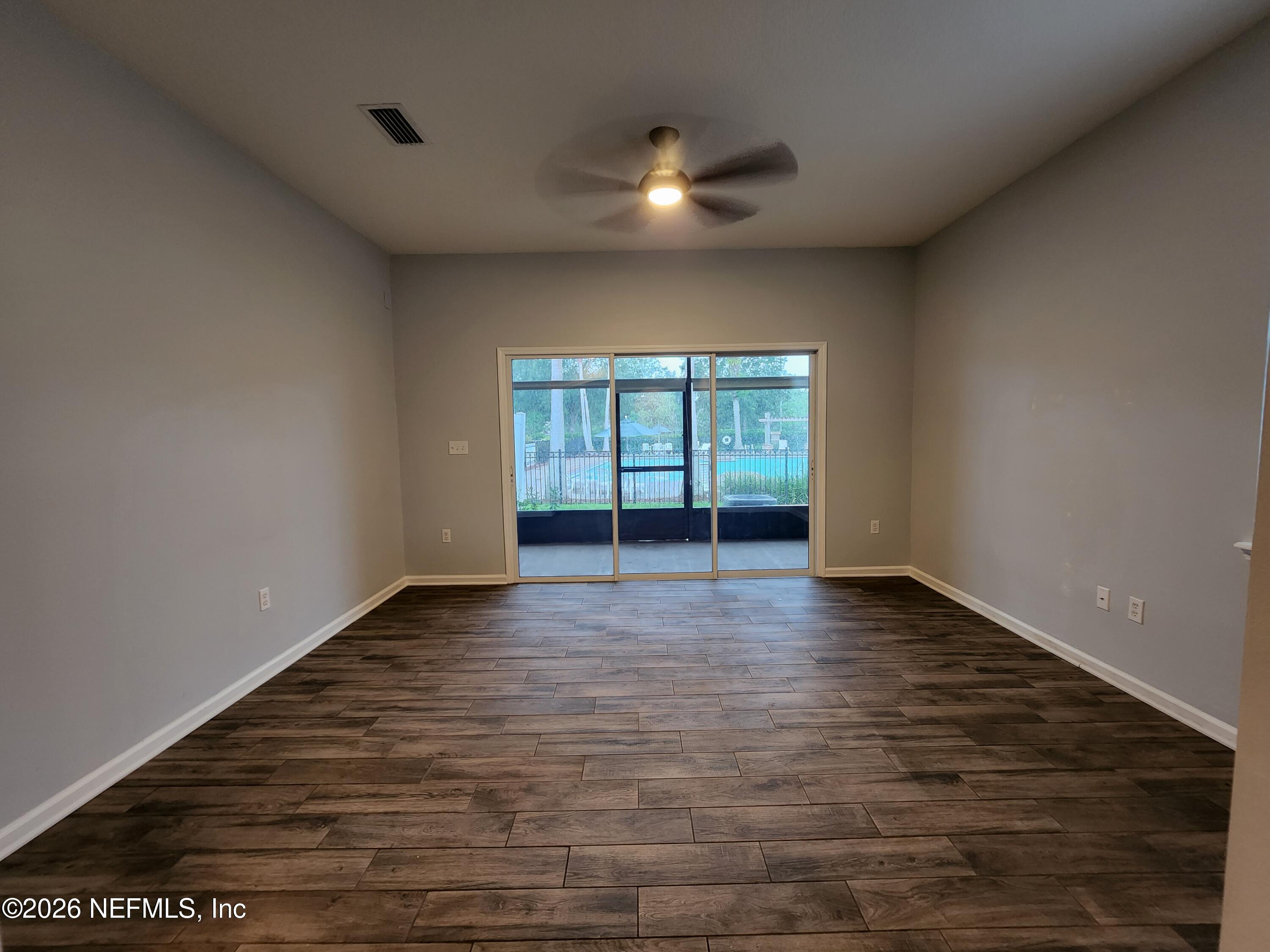 13030 Shallowater Road Jacksonville, FL 32258 - Photo 12 of 27 a view of an empty room with glass door and wooden floor