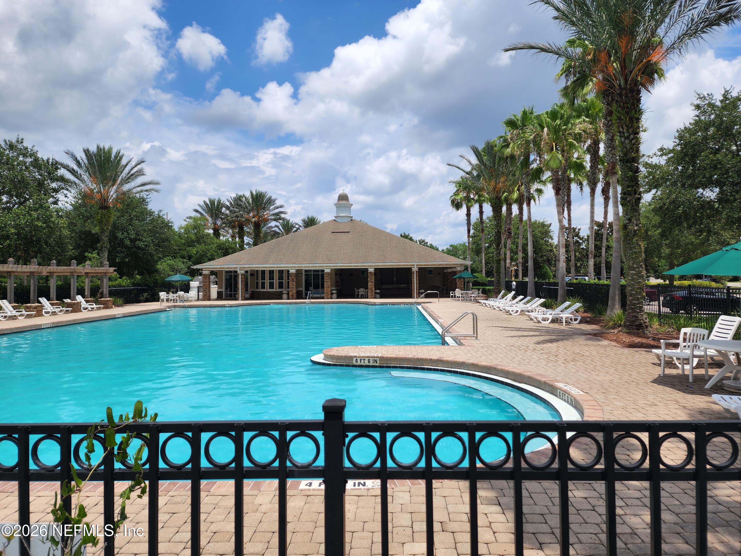 13030 Shallowater Road Jacksonville, FL 32258 - Photo 25 of 27 a view of a swimming pool with lawn chairs under an umbrella