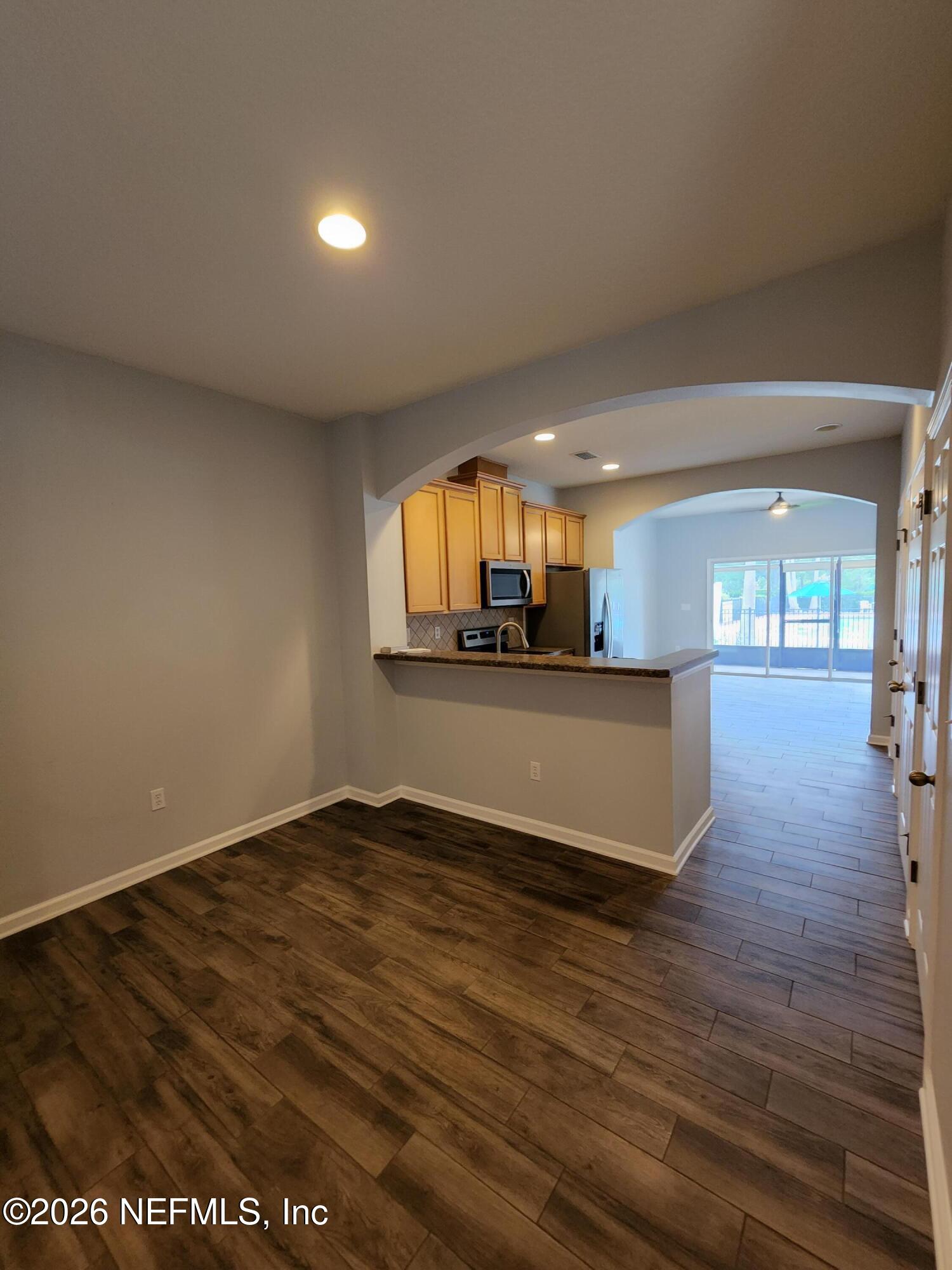 13030 Shallowater Road Jacksonville, FL 32258 - Photo 9 of 27 a view of a living room and kitchen with furniture and a flat screen tv