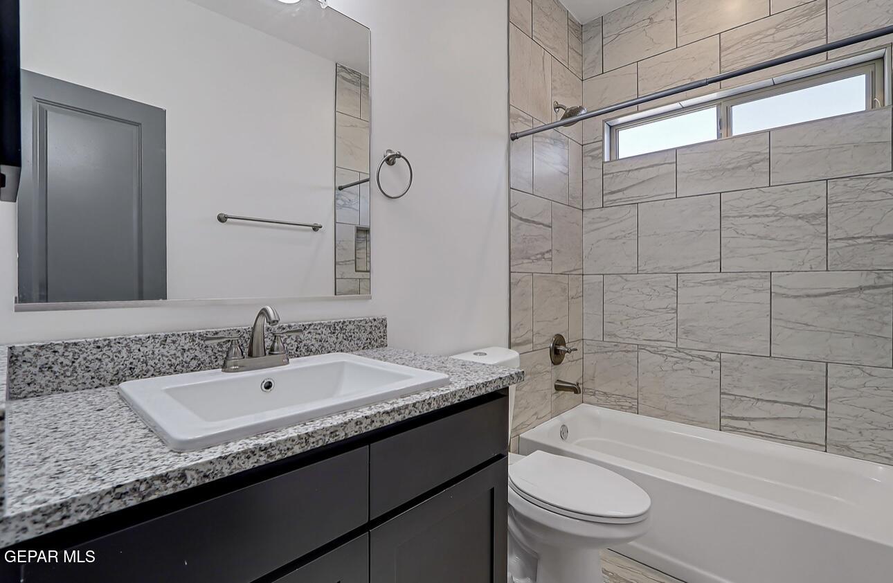 4572 Mark Avizo El Paso, TX 79938 - Photo 14 of 32 a bathroom with a granite countertop sink a toilet and bathtub