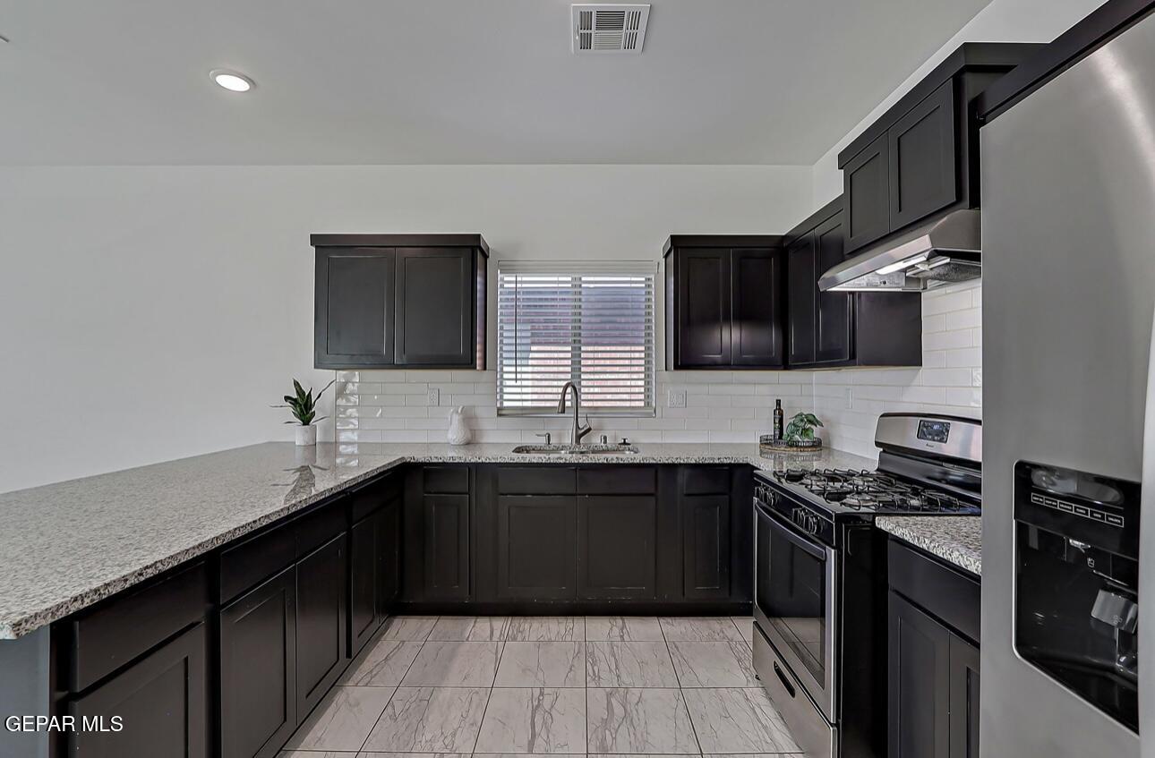 4572 Mark Avizo El Paso, TX 79938 - Photo 7 of 32 a kitchen with stainless steel appliances a sink dishwasher stove and oven with wooden floor