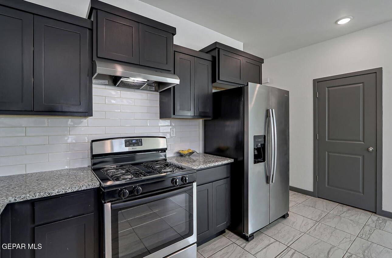 4572 Mark Avizo El Paso, TX 79938 - Photo 9 of 32 a kitchen with stainless steel appliances granite countertop a refrigerator and a stove