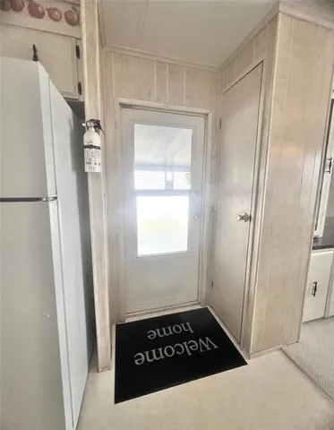 a kitchen with white cabinets and refrigerator